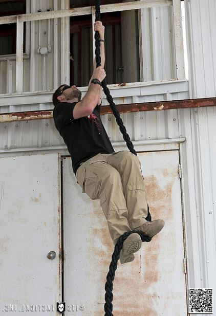 Hoe maak je een touw klimmen. Pak het touw met beide handen boven je hoofd.