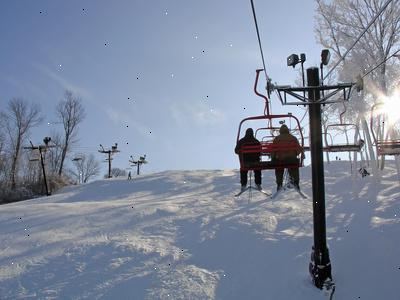 Hoe om uitstappen een skilift met een snowboard. Controleer grote palen die houden de lift voor berichten over het lossen, zoals "voor te bereiden om te lossen" til de veiligheidsbeugel omhoog als je ziet dat teken.
